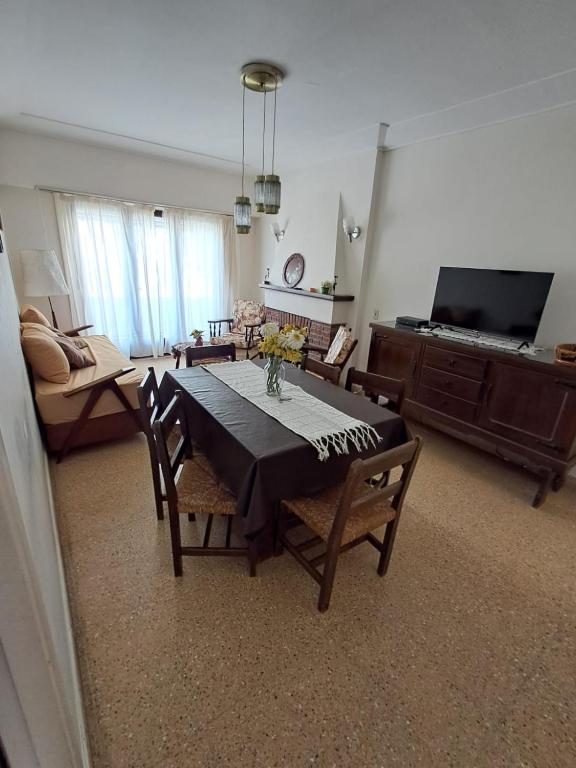 a living room with a table and chairs and a couch at Amplio dpto Miramar centro y playa in Miramar