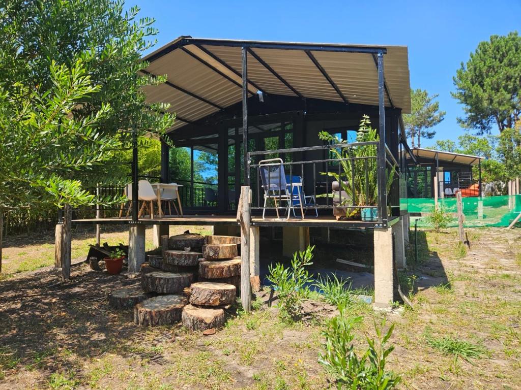 a house with a bunch of logs in front of it at Mainumbi 1 in Balneario Solís