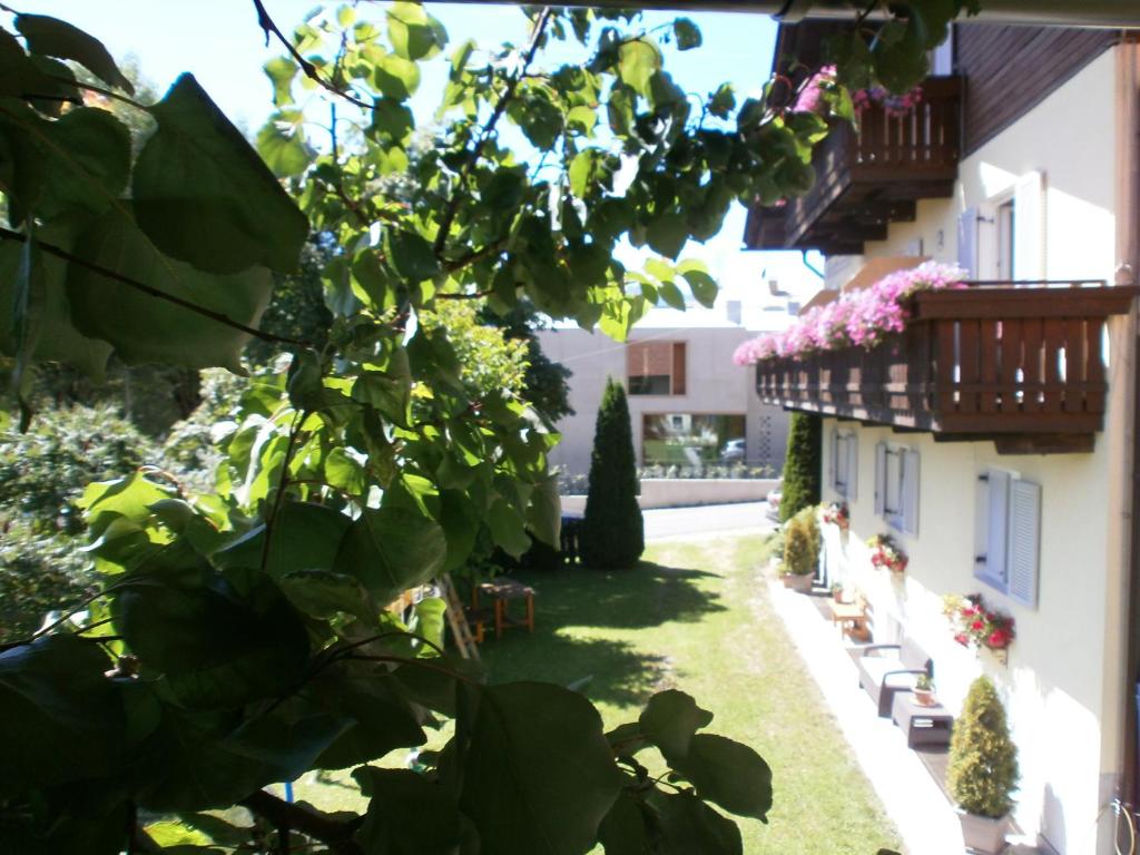 Garni Hattlerhof B&B في برونيكو: ساحة مبنى فيها نباتات وزهور