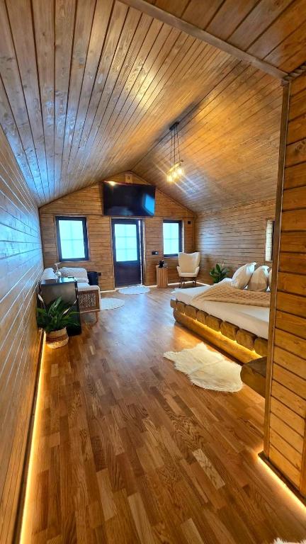 a bedroom with a bed in a room with wooden ceilings at Casuta de la munte in Sărişor