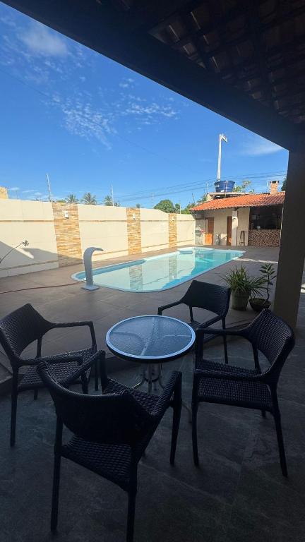 a patio with a table and chairs and a pool at Casa pôr do Sol in Aracaju
