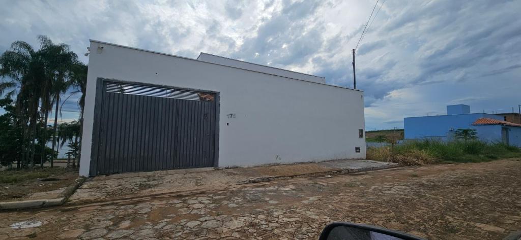 a white building with a door on the side of it at Casa próximo ao lago - 1 in Boa Esperança
