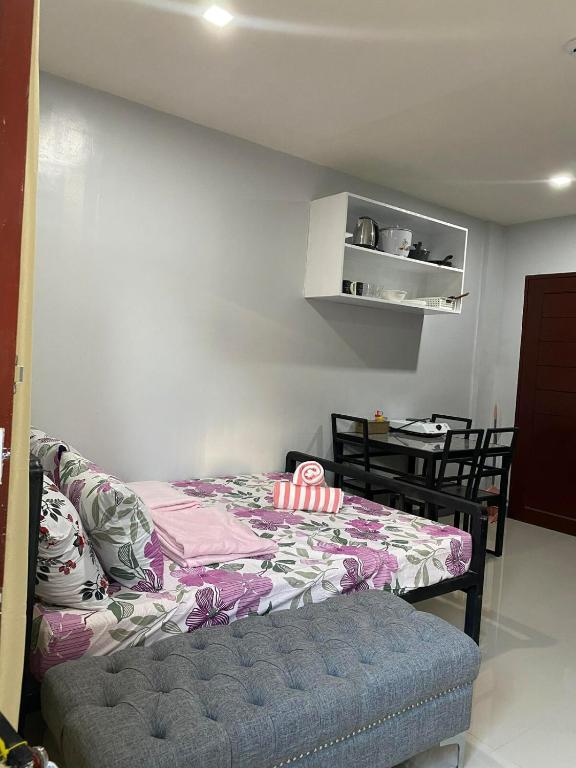 a bedroom with a bed and a table and chairs at Maple Leaf Residences - Unit 2 in Southern Davao