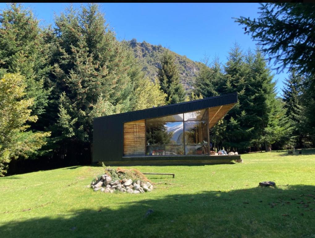 a modern house in a field with trees at Casa Futaleufú parcela in Futaleufú