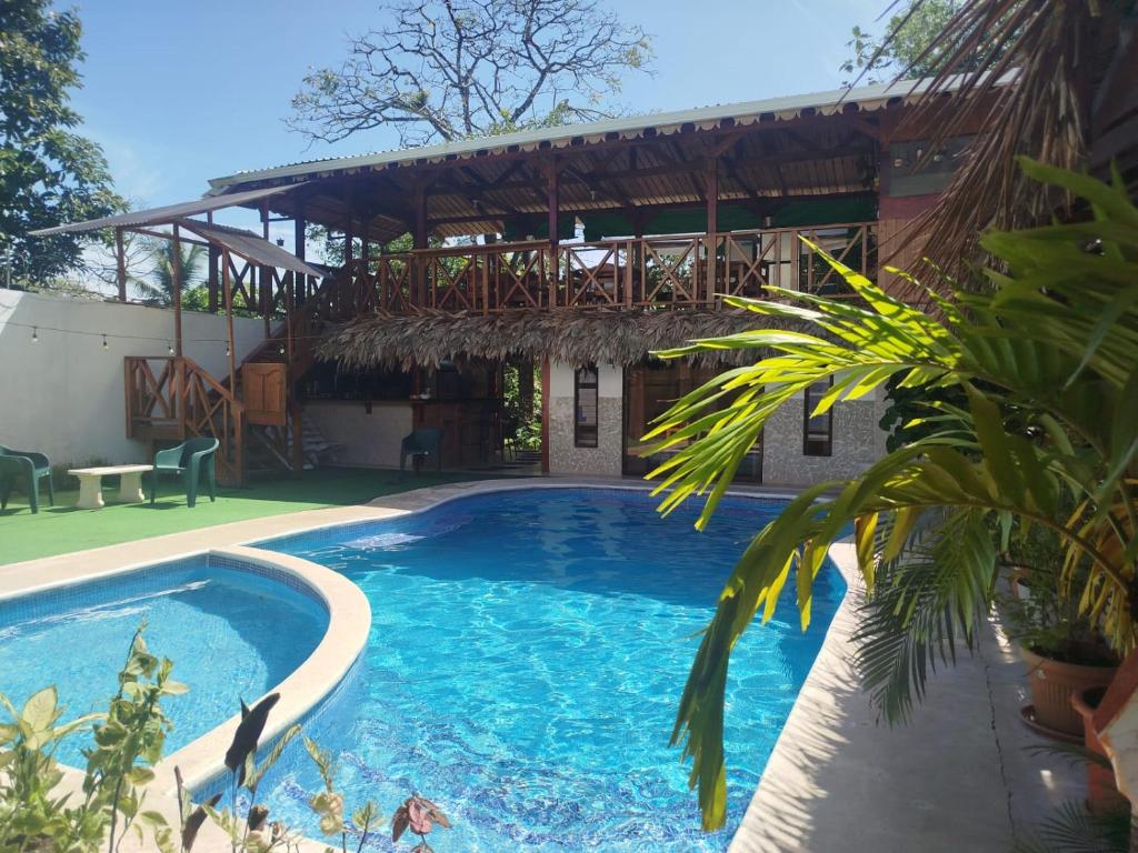 a swimming pool in front of a house at Liahs tortuguero in Tortuguero