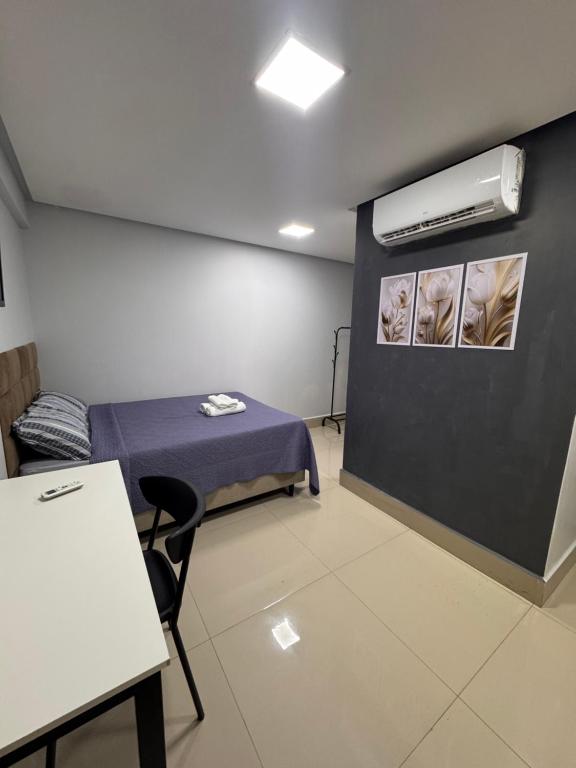 a room with a bed and a air conditioner on a wall at Studio em Anápolis in Anápolis