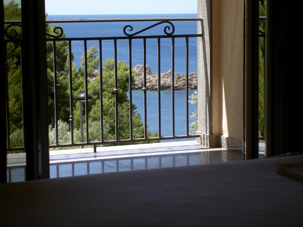 a room with a view of the ocean from a balcony at Apartmani More in Sveti Stefan