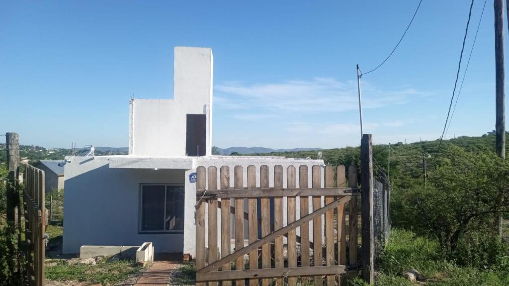 a house with a wooden gate and a fence at Mountain View & Comfort in Villa Santa Cruz del Lago