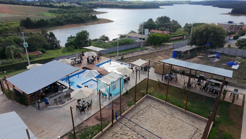 an overhead view of a pool with tables and umbrellas at JK Beach Club Bar e Pousada in Ibiúna