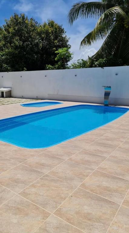 a blue swimming pool next to a white fence at Studio 12 in Santa Cruz Cabrália