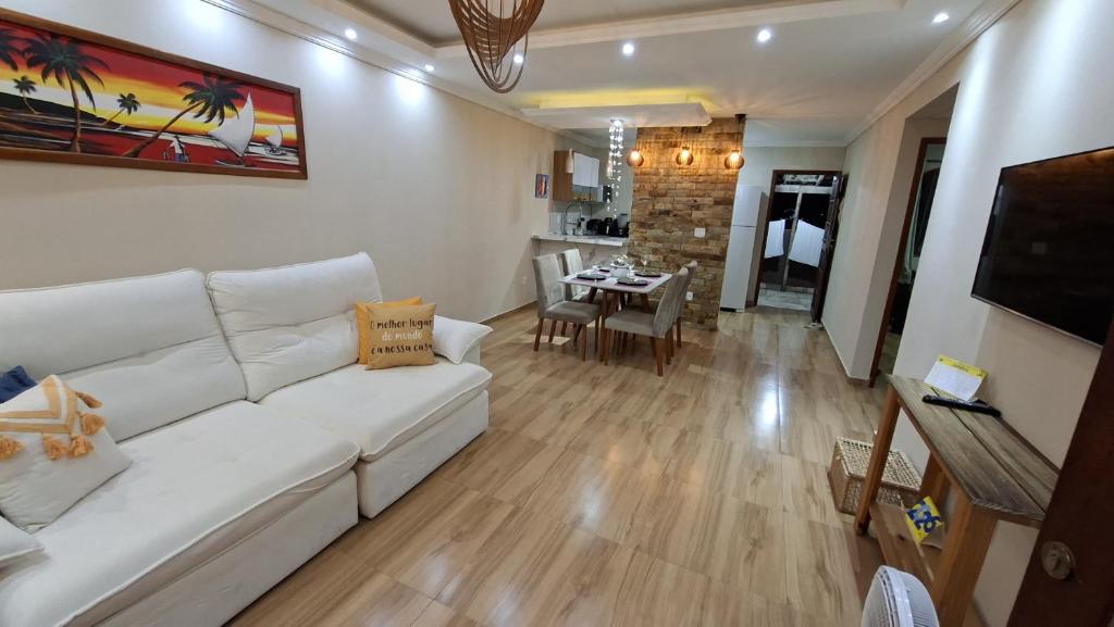 a living room with a white couch and a table at Casa do sossego in Cabo Frio