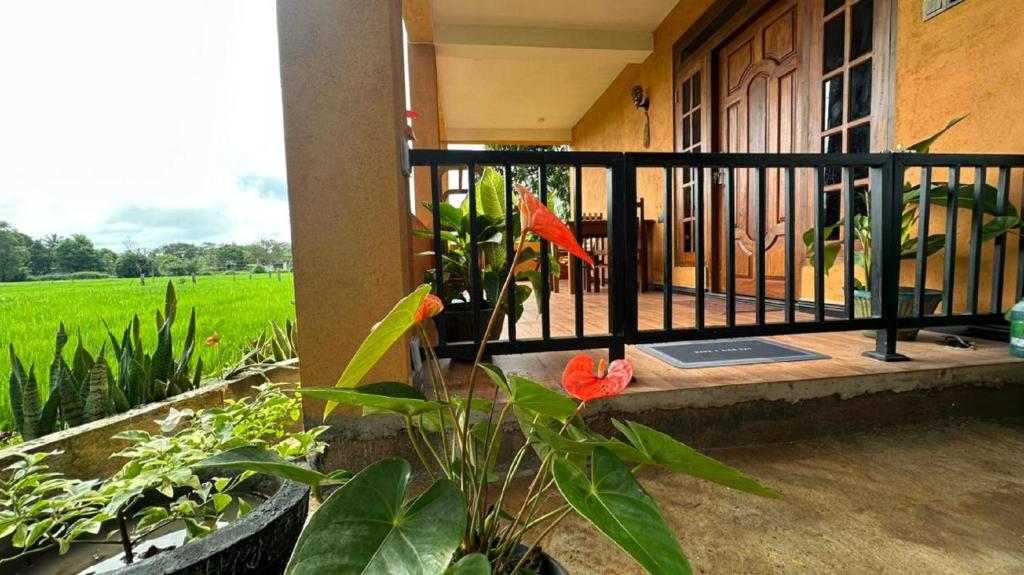 a house with a balcony with a flower on it at Paddy Wind Eco Lodge Sigiriya in Kibissa