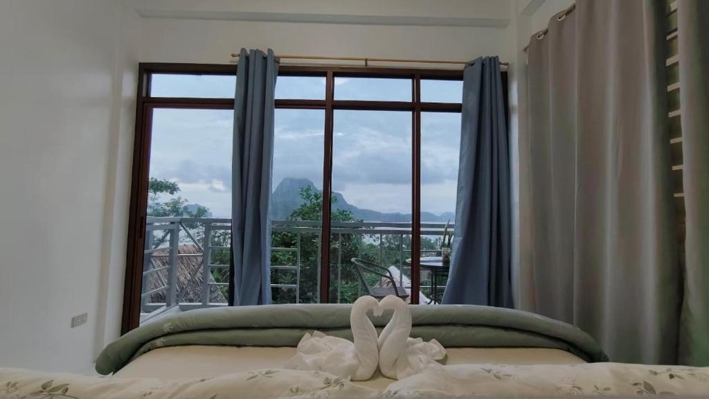 a bedroom with a bed with a large window at Forest Camp El Nido Extension in El Nido