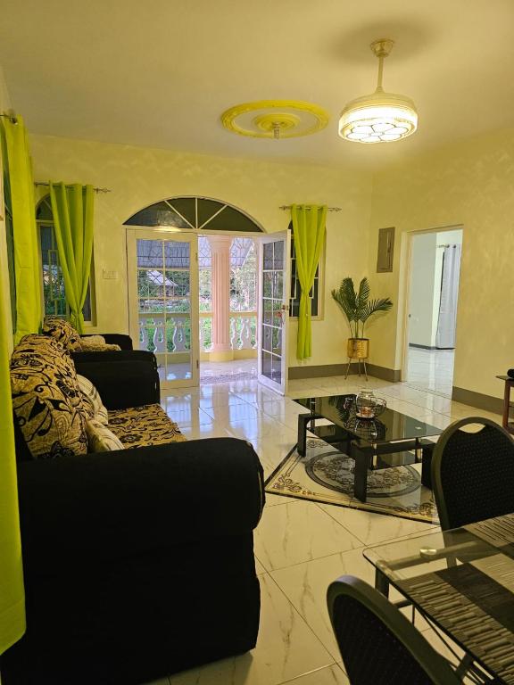 a living room with a couch and a table at Palm Breeze Villa in Green Island