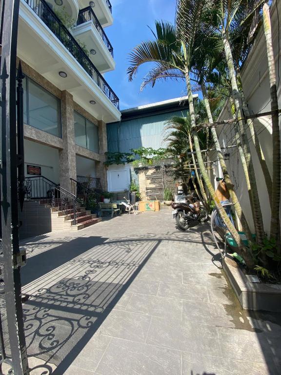 a palm tree and a scooter parked in front of a building at ROSE Appartment in Ho Chi Minh City