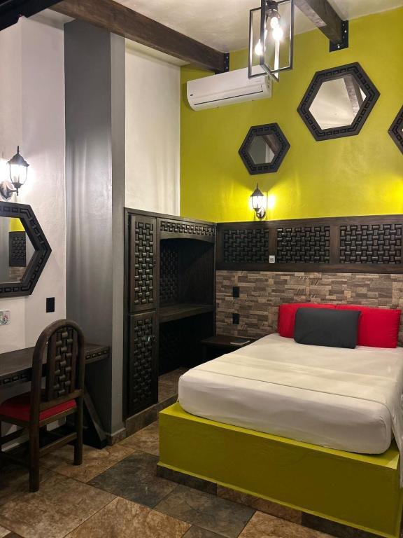 a bedroom with a bed and a yellow wall at Hotel Villa's Camargo in Ixmiquilpan