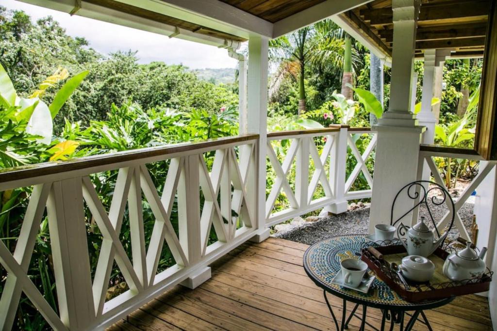 a porch with a table and chairs on it at Reserva Monte Sagrado 1 in Utuado