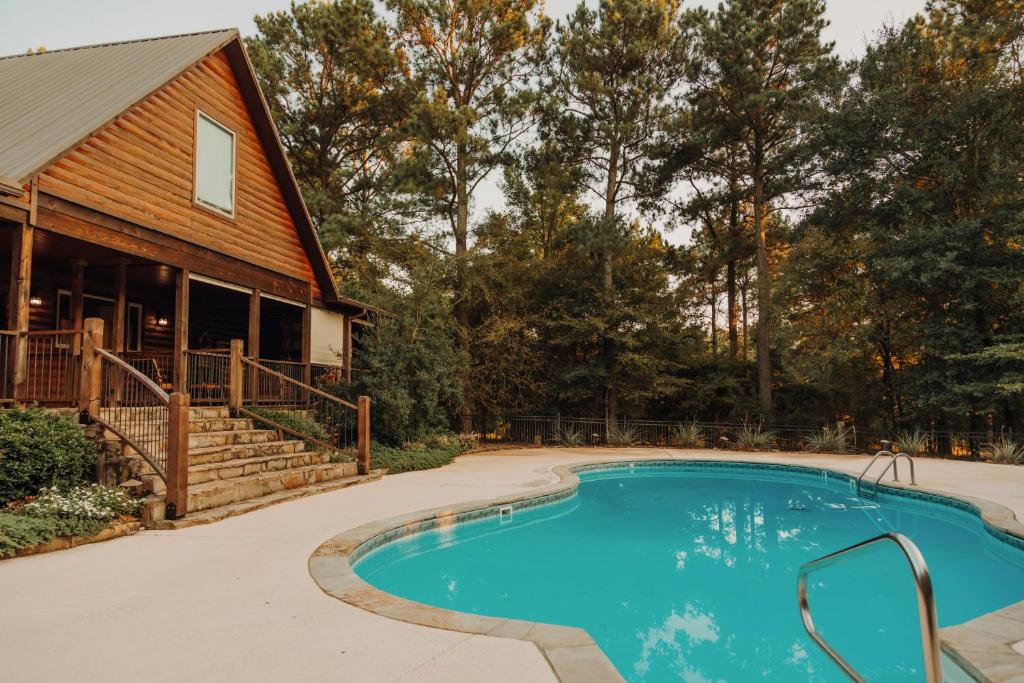 a house with a swimming pool in front of a house at Heated Pool, 7 Bedroom Cabin, 6,000 Square Feet, Arcade! in Broken Bow