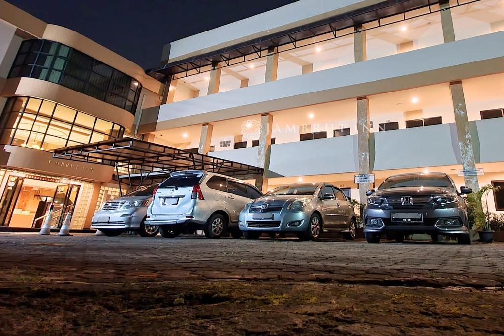 a group of parked cars parked in front of a building at Jambrut Inn in Jakarta