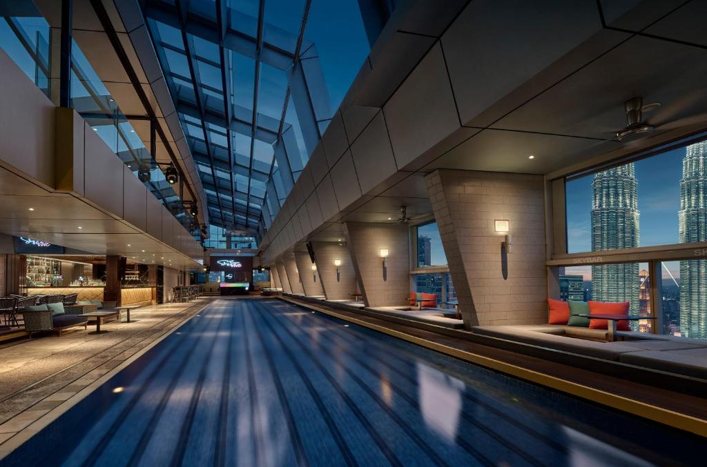 A long indoor pool beside floor-to-ceiling windows and city views.