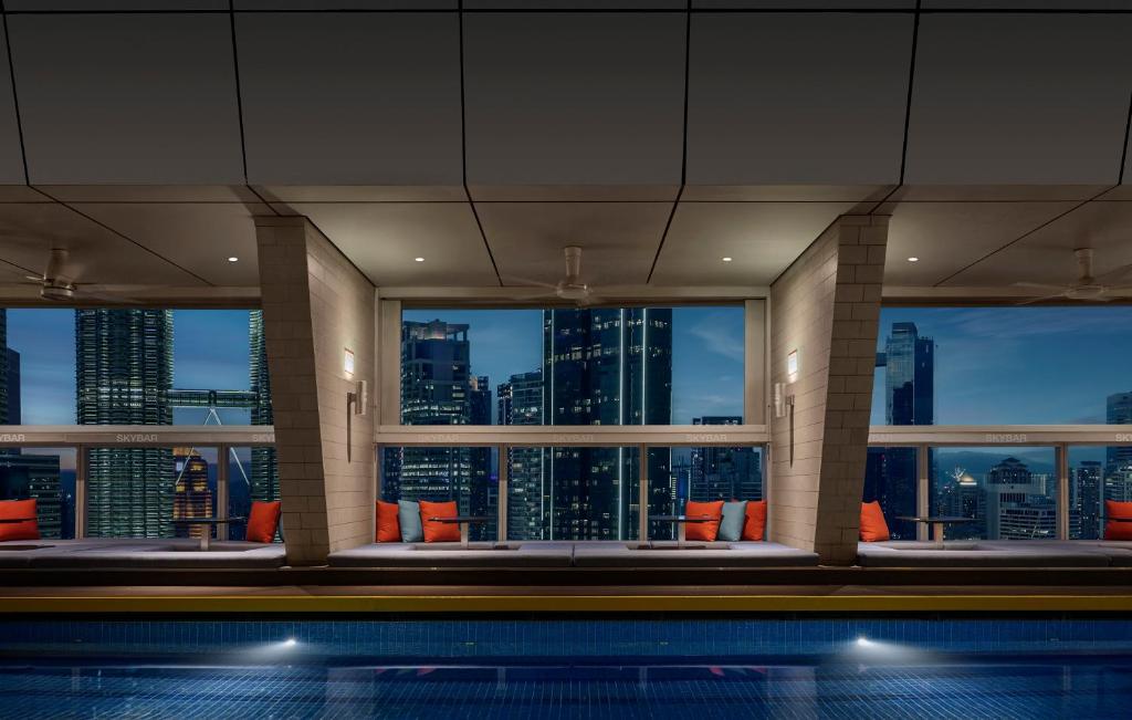 A rooftop-style indoor pool overlooks Kuala Lumpur through large windows.