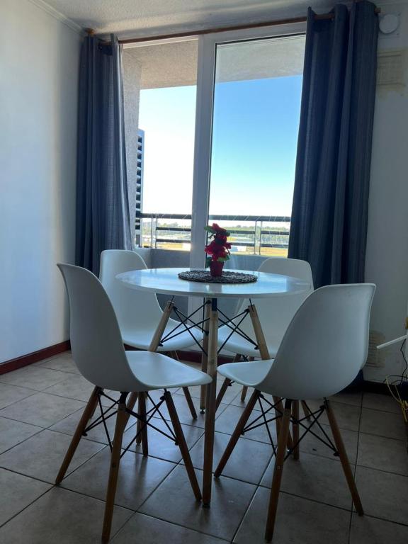 a table and chairs in a room with a window at Vista a los volcanes in Puerto Montt