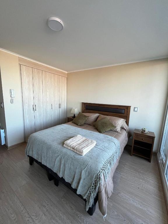 a bedroom with a large bed with a wooden headboard at Genesis in Chillán
