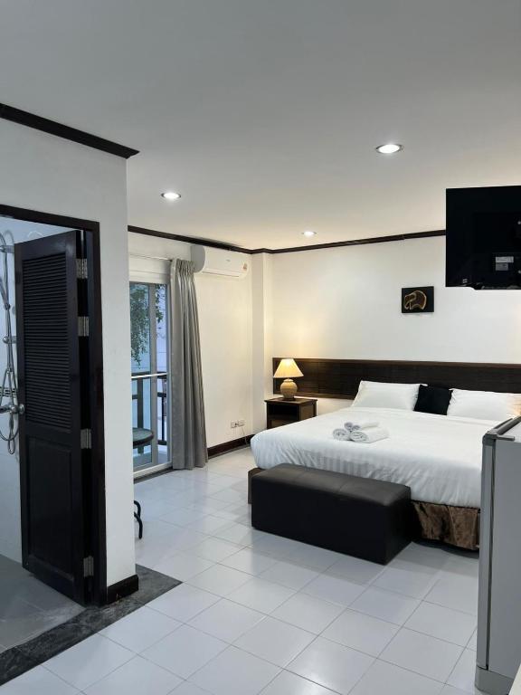 a bedroom with a bed and a flat screen tv at Pathaya in Ban Kata