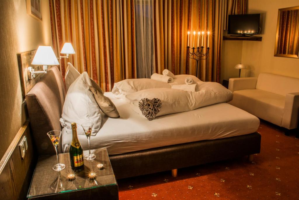 a hotel room with a bed and a table with wine glasses at Pension Savisalo in Ramsau am Dachstein