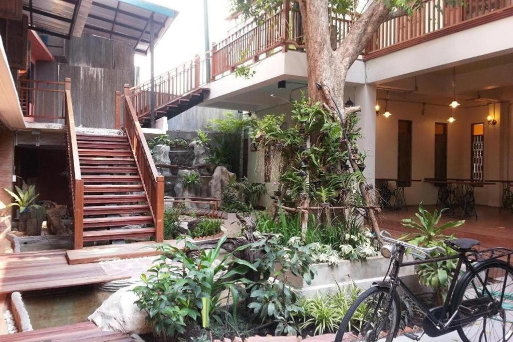 a bike parked in front of a building with a staircase at P1 House Phitsanulok in Phitsanulok