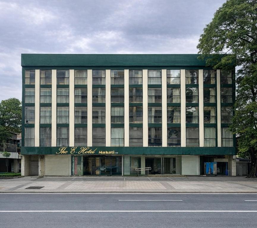 a large building with a sign on the front of it at The E-Hotel Makati in Manila