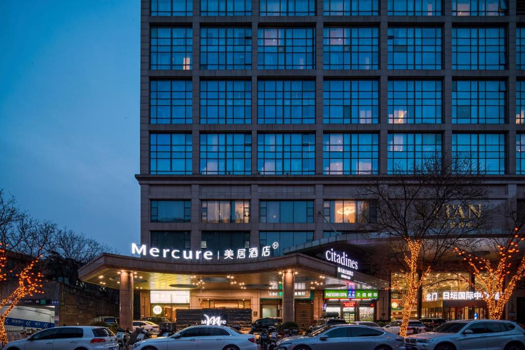 a large building with cars parked in front of it at Mercure Beijing City Center in Beijing