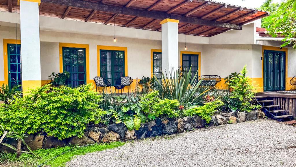 a house with a porch with a bench and plants at Shanti Home in Tepoztlán