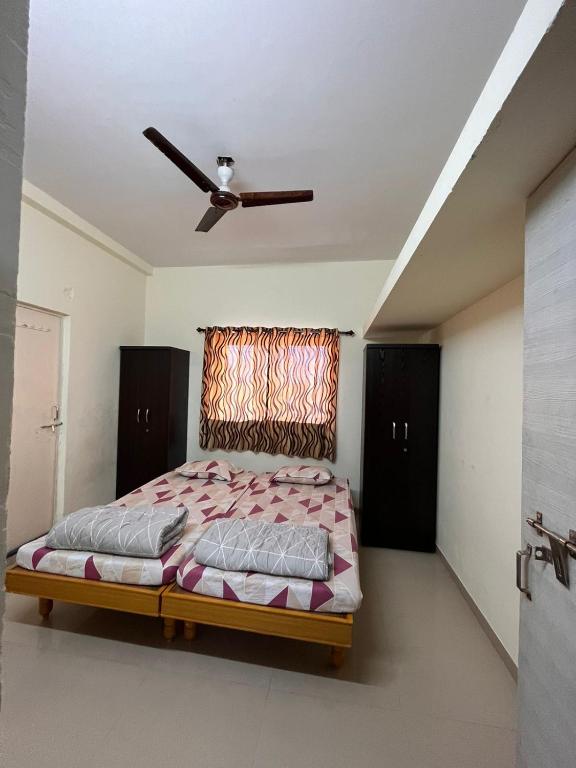 a bedroom with a bed and a ceiling fan at Home Nest in Anand