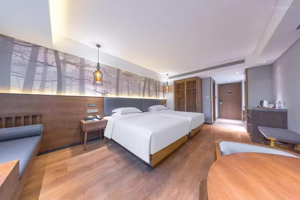 a bedroom with a large white bed and a couch at True Go S Hotel - Shenzhen Convention and Exhibition Center Union Square Branch in Shenzhen