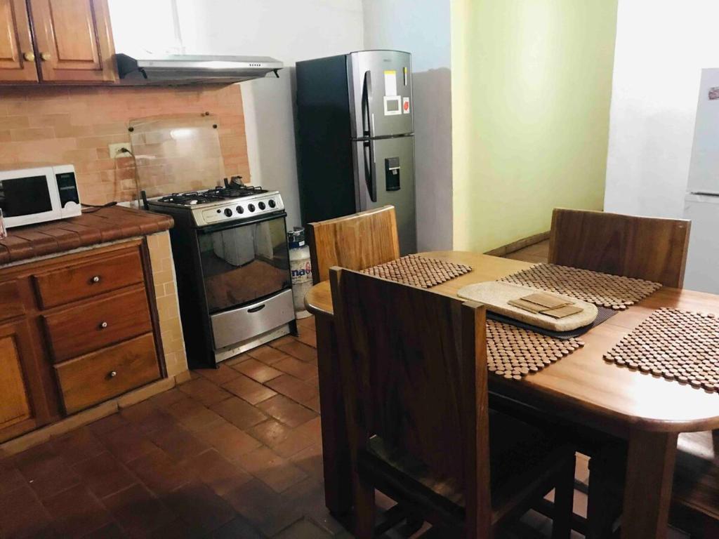 a kitchen with a table and a stove and refrigerator at Casa estilo campestre in Chitré
