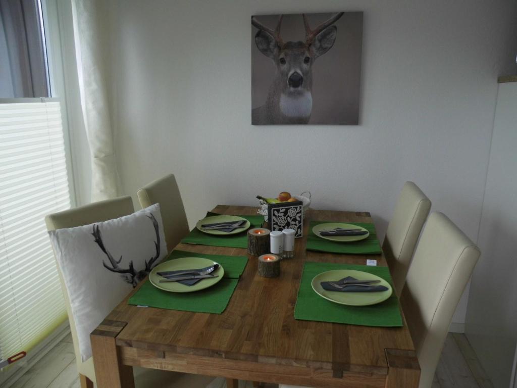 ブラウンラーゲにあるFewo Schröder - Harzflairの木製テーブル(緑のナプキンと鹿の頭付)