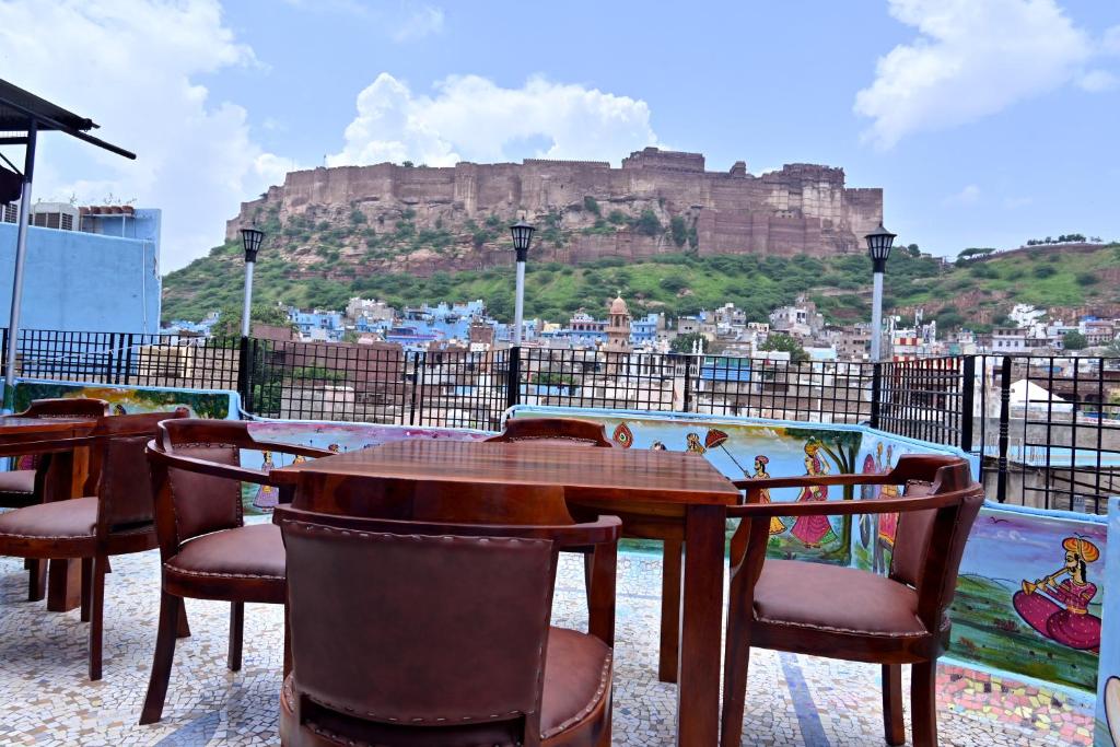 a table and chairs with a view of the castle at The Rajputana Heritage in Jodhpur