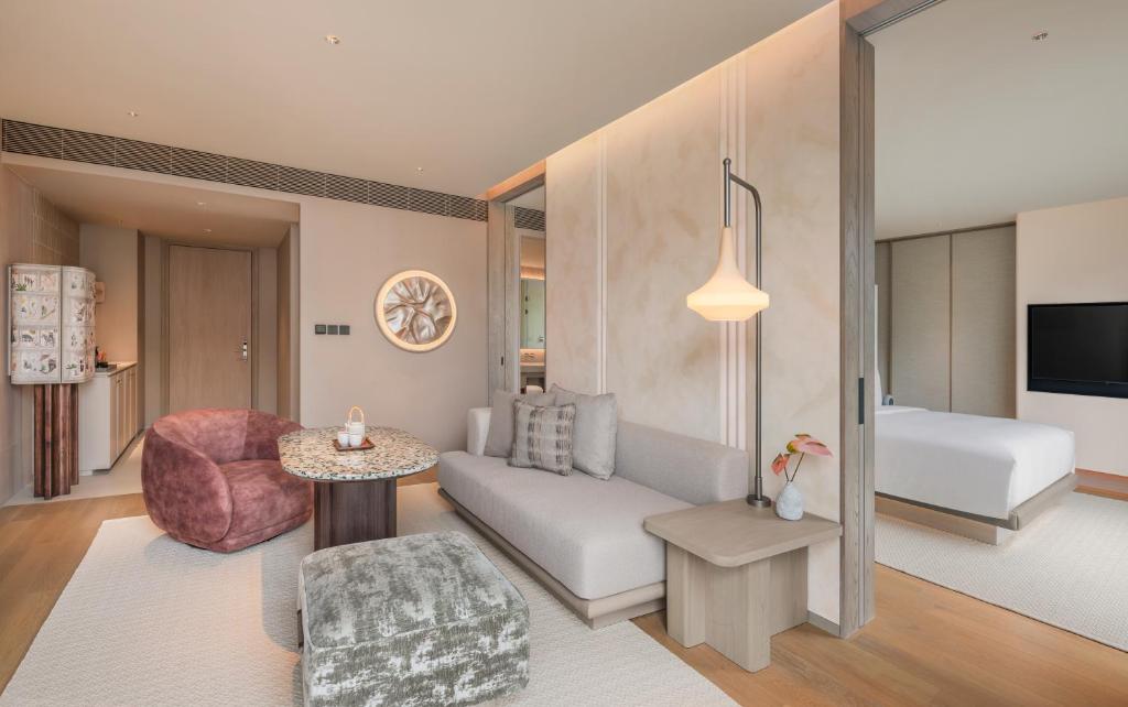 An open-plan suite view showing the lounge, kitchenette and partially separated bedroom.