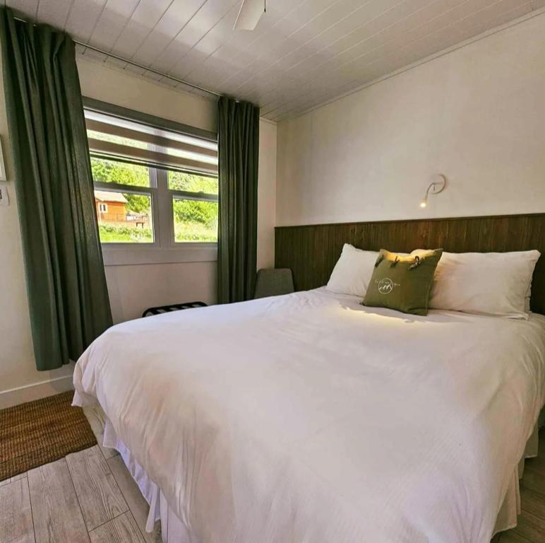 a bedroom with a large white bed with a window at En Route Vers l'Infini in Perce