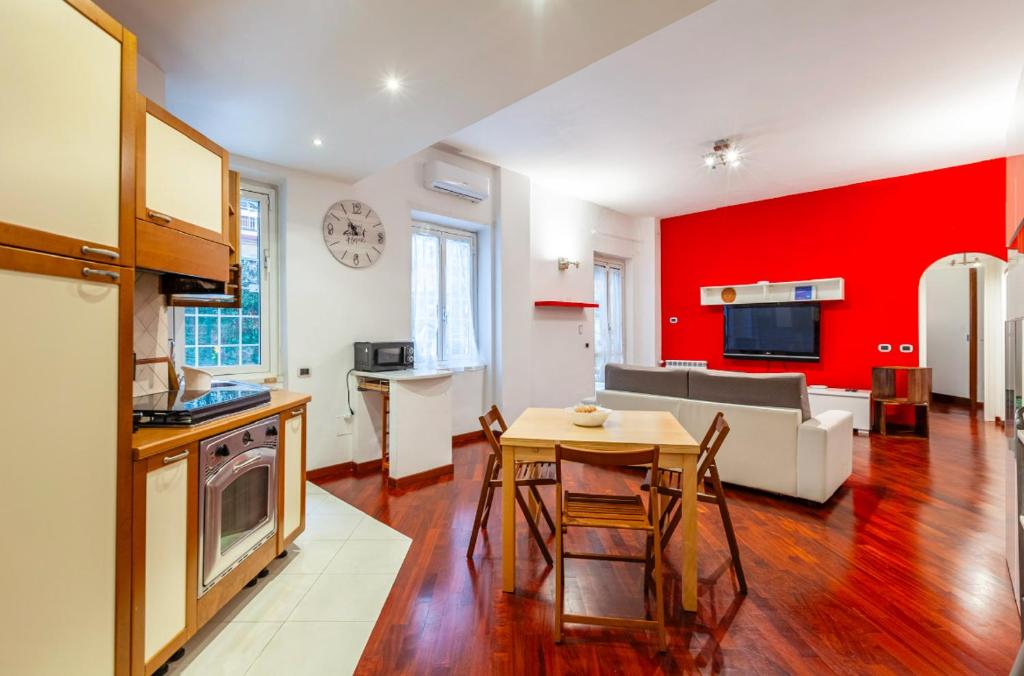 a kitchen and living room with a red wall at Vacanze Romane con giardino in Rome