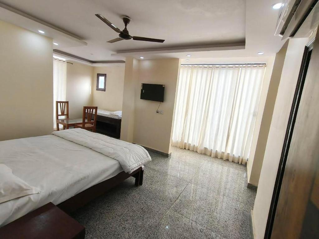 a bedroom with a bed and a flat screen tv at RSR event service in Faridabad