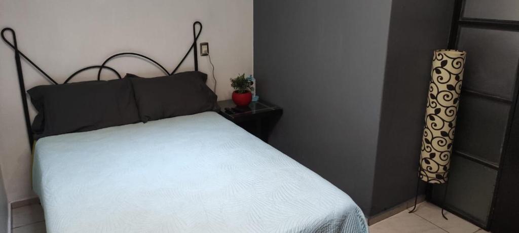 a bedroom with a white bed with a black headboard at Casa tabachin in Arandas