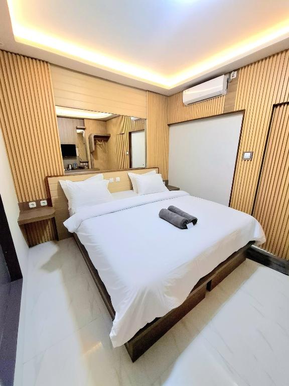 a bedroom with a large white bed in a room at 7 Day Inn in Gili Trawangan