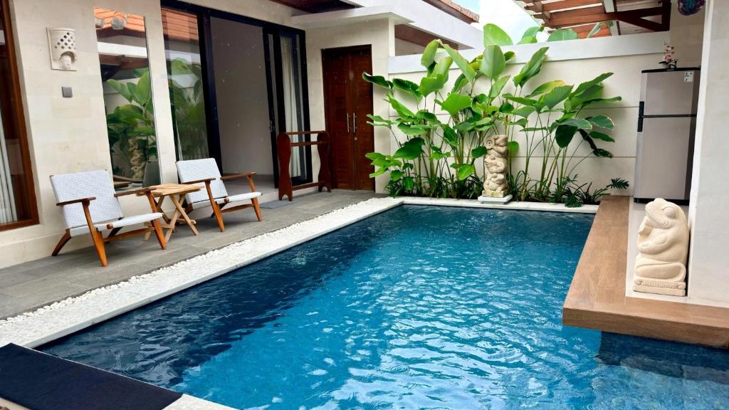 a swimming pool in the middle of a house at Emstaliese & Palmarosa Villas Seminyak in Legian