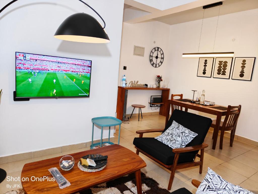 a living room with a tv on the wall at Twiga Luxe in Arusha