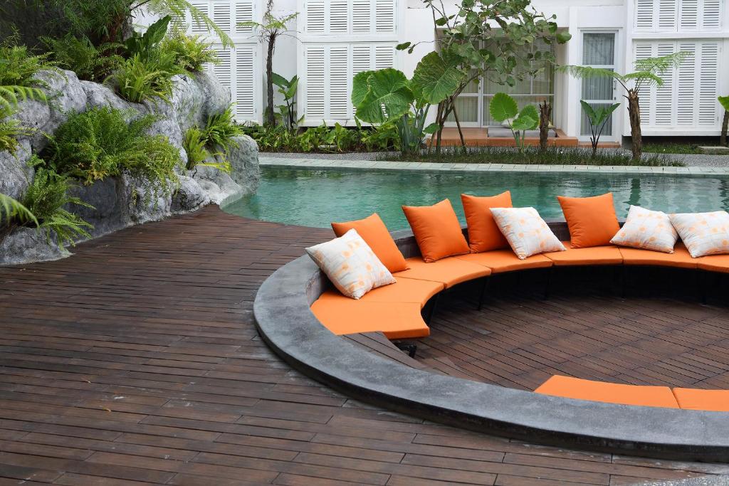 an orange couch sitting in front of a pool at YATS Colony in Yogyakarta