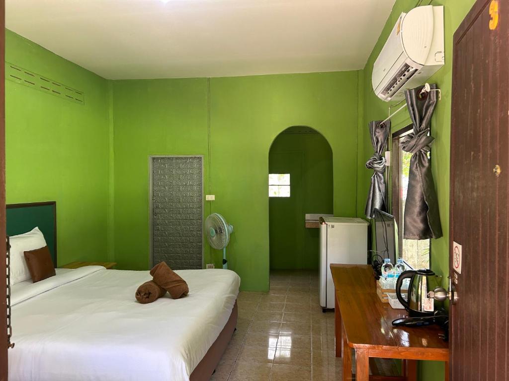 a green room with two beds and a desk at ABC Bungalow in Ban Tai