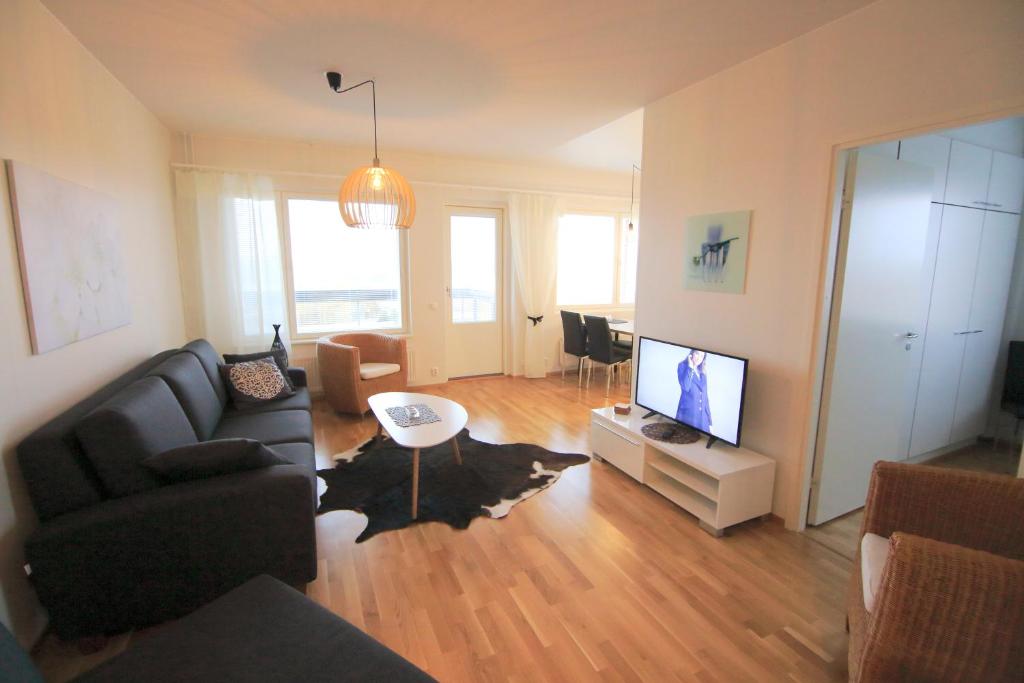 a living room with a couch and a flat screen tv at Northern Lights Apartment in Rovaniemi