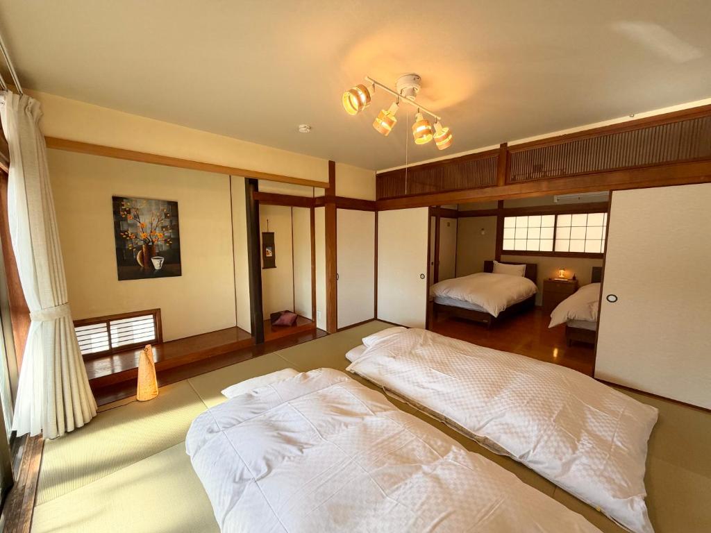 a large bedroom with two beds and a window at かみくまハウス in Kumamoto